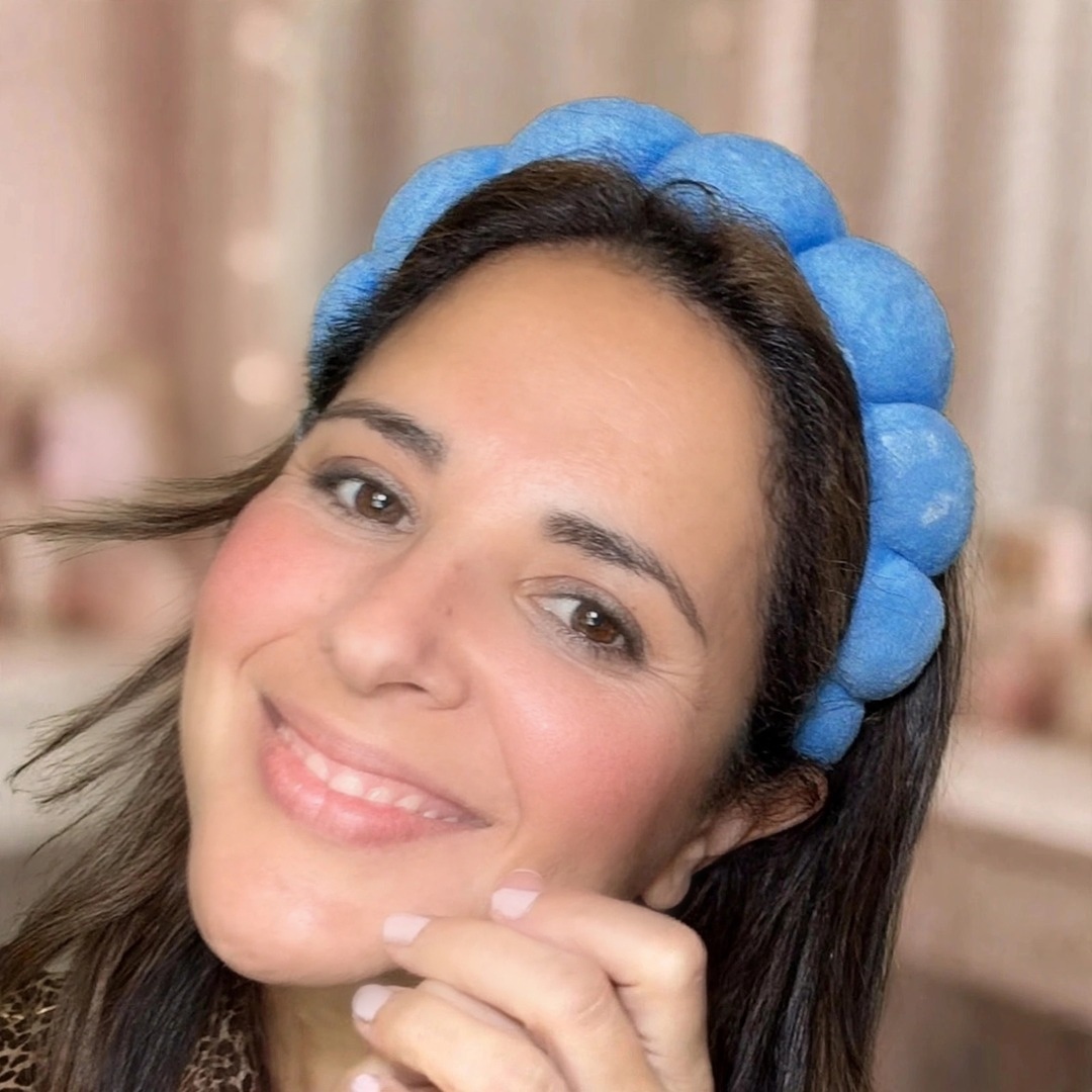 Caro Manzano sonriendo con una diadema azul, foto cálida de bienvenida
